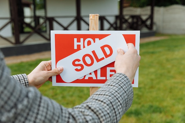 home for sale sign with a sold sticker over it